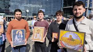 Eine Gruppe von Männern ist mit verschiedenen christlichen Bildnissen auf der Abtreibungsdemo.