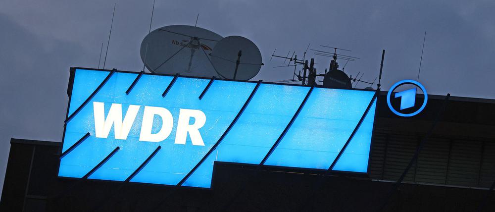 ARCHIV - 16.08.2022, Nordrhein-Westfalen, Köln: Ein Logo des WDR (Westdeutscher Rundfunk) leuchtet auf dem Dach des Senders.