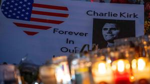 Kerzen stehen vor einem Foto des ermordeten Charlie Kirk