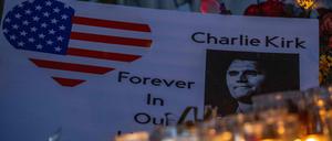 Kerzen stehen vor einem Foto des ermordeten Charlie Kirk