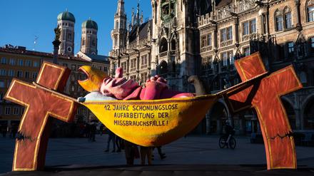 Die Plastik „Der Hängemattenbischof“ steht auf dem Marienplatz. Ein Protestbündnis von verschiedenen Organisationen demonstriert damit gegen „die Vertuschung von kirchlichem Missbrauch“.