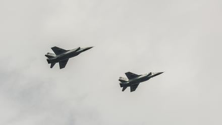 two airplanes a mig 31 flying against the cloudy sky 