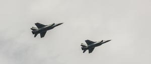 two airplanes a mig 31 flying against the cloudy sky 