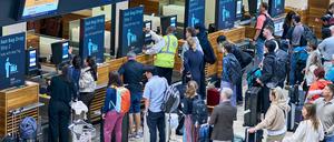 Zahlreiche Fluggäste warten vor den Check-in-Schaltern im Terminal 1 des Flughafens Berlin Brandenburg.
