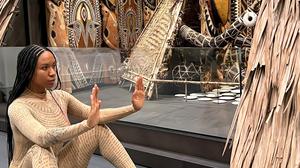 Performance-Künstlerin Kristy Nataraja mit einer Performance vor einem Häuserkubus aus Papua-Neuguinea.