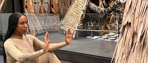 Performance-Künstlerin Kristy Nataraja mit einer Performance vor einem Häuserkubus aus Papua-Neuguinea.