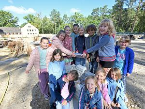 Die Kinder versenkten die Zeitkapsel im Grundstein des Neubaus.