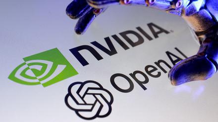 Eine Roboterhand greift nach den Logos der Technologiekonzerne Nvidia und OpenAI auf einem Display.