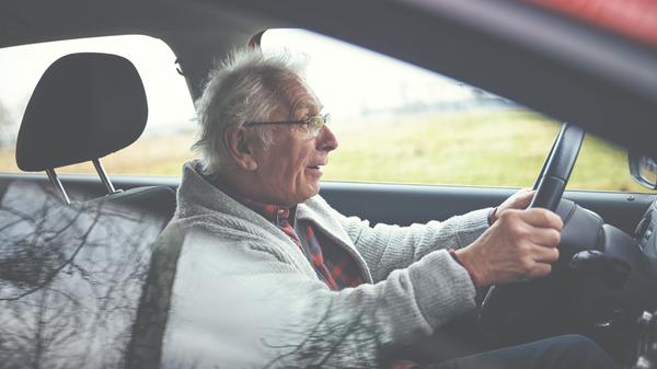 Ein alter Mann sitzt im Auto am Steuer. (Symbolbild)