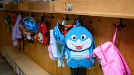 Kinderrucksäcke hängen in der Garderobe einer Kita. (Symbolfoto)