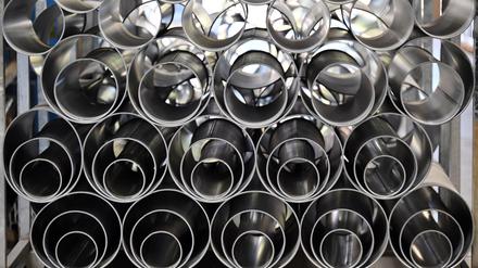 Metallrohre liegen in einer Fertigungshalle eines Industriebetriebes.