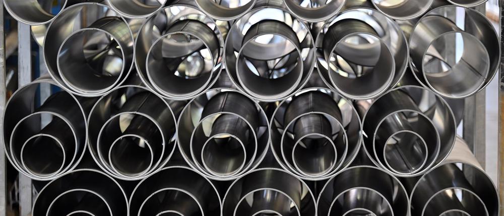 Metallrohre liegen in einer Fertigungshalle eines Industriebetriebes.