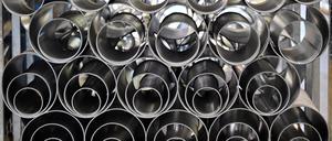 Metallrohre liegen in einer Fertigungshalle eines Industriebetriebes.