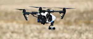 Eine Drohne vom Typ DJI Inspire 1 mit der Kamera Xenmuse X3 fliegt über ein Feld.