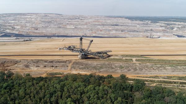 ARCHIV - 30.08.2019, Nordrhein-Westfalen, Morschenich: Ein Braunkohlebagger steht im Tagebau Hambach (Luftaufnahme mit einer Drohne). Im Vordergrund ist der Hambacher Wald zu sehen.  (zu dpa: «Aktivisten besetzen Braunkohlebagger im Tagebau Hambach») Foto: Henning Kaiser/dpa +++ dpa-Bildfunk +++