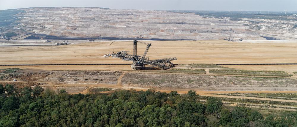 ARCHIV - 30.08.2019, Nordrhein-Westfalen, Morschenich: Ein Braunkohlebagger steht im Tagebau Hambach (Luftaufnahme mit einer Drohne). Im Vordergrund ist der Hambacher Wald zu sehen.  (zu dpa: «Aktivisten besetzen Braunkohlebagger im Tagebau Hambach») Foto: Henning Kaiser/dpa +++ dpa-Bildfunk +++