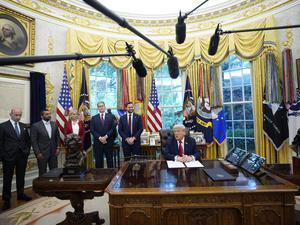 US-Präsident Donald Trump unterzeichnet vor der Presse Dekrete im Weißen Haus.