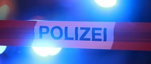 Blaulichter leuchten hinter einem Absperrband der Polizei. (Symbolbild)