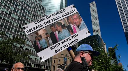Eine Person hält ein Plakat mit Bildern von US-Präsident Donald Trump und Jeffrey Epstein hoch (Symbolbild).