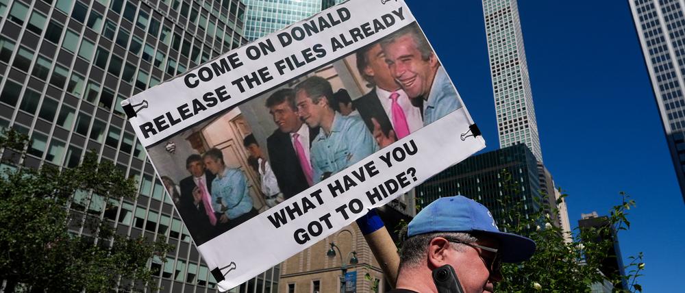 Eine Person hält ein Plakat mit Bildern von US-Präsident Donald Trump und Jeffrey Epstein hoch (Symbolbild).