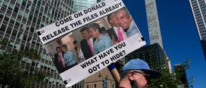 Eine Person hält ein Plakat mit Bildern von US-Präsident Donald Trump und Jeffrey Epstein hoch (Symbolbild).