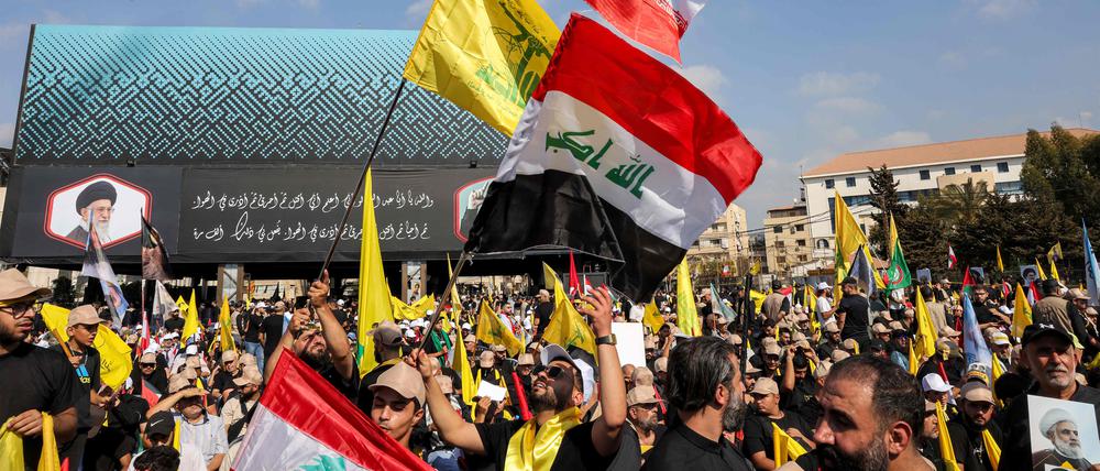 Hisbollah-Anhänger schwenken die Flaggen.