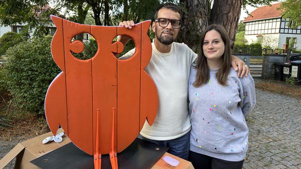Katharina Spilker und Raik Hölzel neben einer Eule aus Holz.