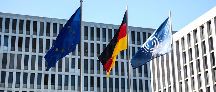 The flags of (L-R) the European Union, Germany and the Federal Intelligence Service BND (Bundesnachrichtendienst) are seen in front of the BND headquarters, on the day of the handover of the office, in Berlin, Germany, September 11, 2025. (Photo by Liesa Johannssen / POOL / AFP)