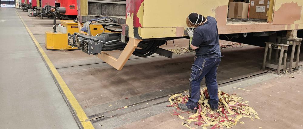 Handarbeit: Mit dem Spachtel wird die Farbe abgekratzt. 
