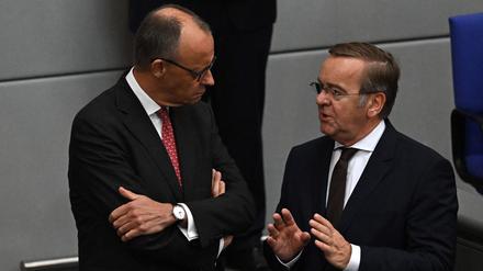 German Chancellor Friedrich Merz (L) chats with German Defence Minister Boris Pistorius  at the Bundestag during a general debate on budget, in Berlin on September 17, 2025. (Photo by RALF HIRSCHBERGER / AFP)