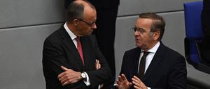 German Chancellor Friedrich Merz (L) chats with German Defence Minister Boris Pistorius  at the Bundestag during a general debate on budget, in Berlin on September 17, 2025. (Photo by RALF HIRSCHBERGER / AFP)