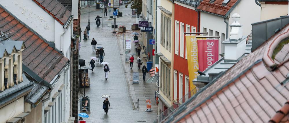 Passanten gehen bei Regen durch die Zwickauer Innenstadt.