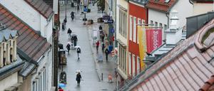 Passanten gehen bei Regen durch die Zwickauer Innenstadt. 