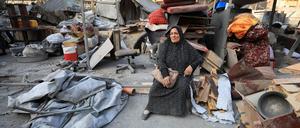 Eine Frau in Gaza sitzt inmitten von Trümmern.