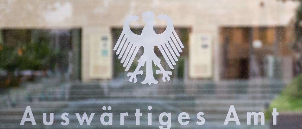 Der Bundesadler und der Schriftzug „Auswärtiges Amt“ sind an einer Glasscheibe an einem Eingang zum Auswärtigen Amt zu sehen.