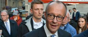 Der Bundeskanzler Friedrich Merz (CDU) kommt mit einer Kerze in der Hand zum Kerzensingen auf dem Marktplatz von Halle. 
