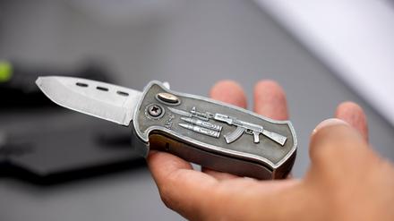 Ein Polizeibeamter hält ein sichergestelltes verbotenes Springmesser in der Hand. 