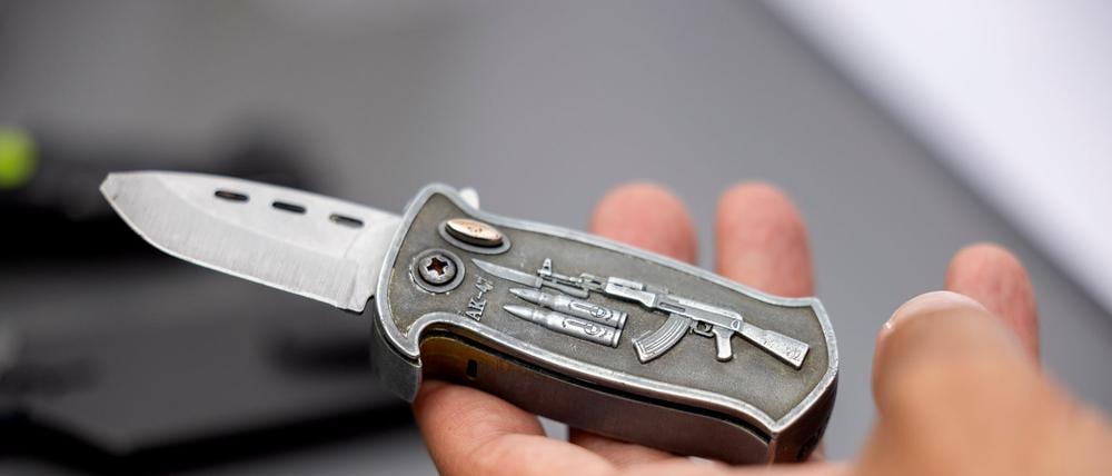 Ein Polizeibeamter hält ein sichergestelltes verbotenes Springmesser in der Hand. 