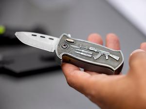 Ein Polizeibeamter hält ein sichergestelltes verbotenes Springmesser in der Hand. 