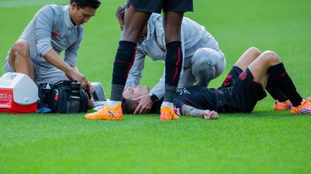 Bayer Leverkusens Kapitän Alejandro Grimaldo liegt nach einem Zusammenprall auf dem Boden. 