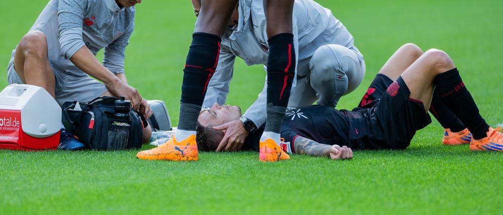 Bayer Leverkusens Kapitän Alejandro Grimaldo liegt nach einem Zusammenprall auf dem Boden. 
