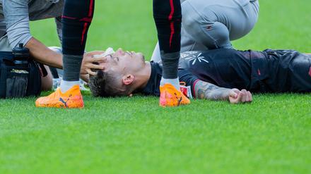 Bayer Leverkusens Kapitän Alejandro Grimaldo liegt nach einem Zusammenprall auf dem Boden. 