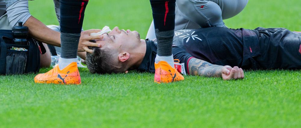 Bayer Leverkusens Kapitän Alejandro Grimaldo liegt nach einem Zusammenprall auf dem Boden. 