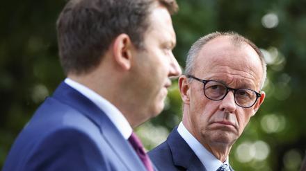 Kanzler Friedrich Merz (CDU) schaut bei einer Pressekonferenz auf den Finanzminister von der SPD, Lars Klingbeil (rechts).