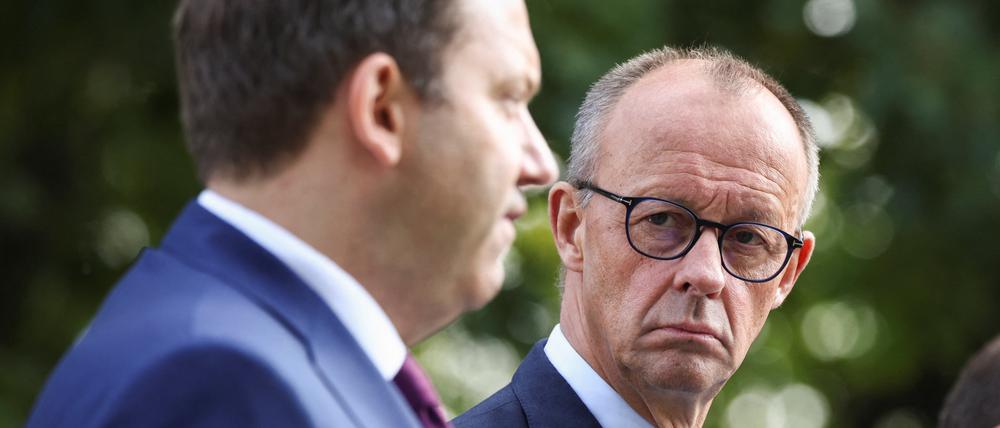 Kanzler Friedrich Merz (CDU) schaut bei einer Pressekonferenz auf den Finanzminister von der SPD, Lars Klingbeil (rechts).