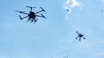 Eine autonom operierende Abwehrdrohne (l) bringt bei einer Vorführung am Tag der Bundeswehr in Hamburg eine Angriffsdrohne durch Beschuss mit einem Netz zum Absturz. 