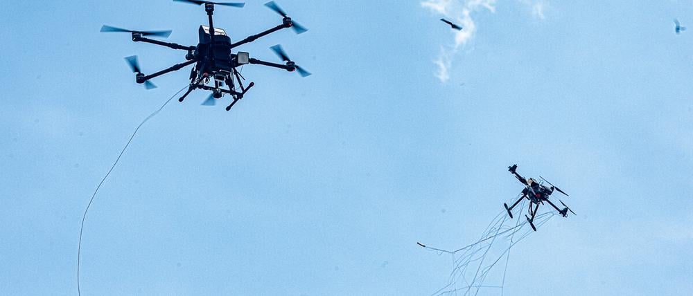 Eine autonom operierende Abwehrdrohne (l) bringt bei einer Vorführung am Tag der Bundeswehr in Hamburg eine Angriffsdrohne durch Beschuss mit einem Netz zum Absturz. 