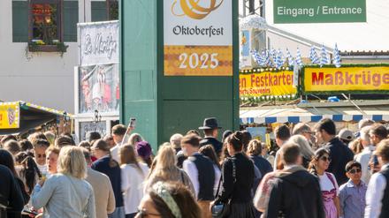 Wiesn-Besucher gehen durch den Haupteingang zum 190. Münchner Oktoberfest auf der Theresienwiese. 