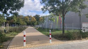 Der verpollerte Parkweg an der Werneuchener Wiese in Prenzlauer Berg, rechts im Bild die Schule, die als temporäre Schuldrehscheibe fungiert.
Foto: Patricia Wolf