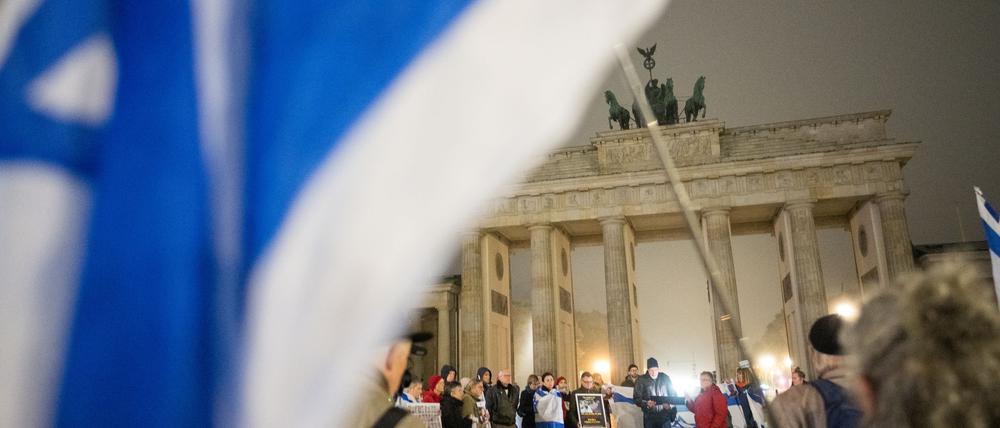 Menschen erinnern am Brandenburger Tor an die Opfer des 7. Oktober.